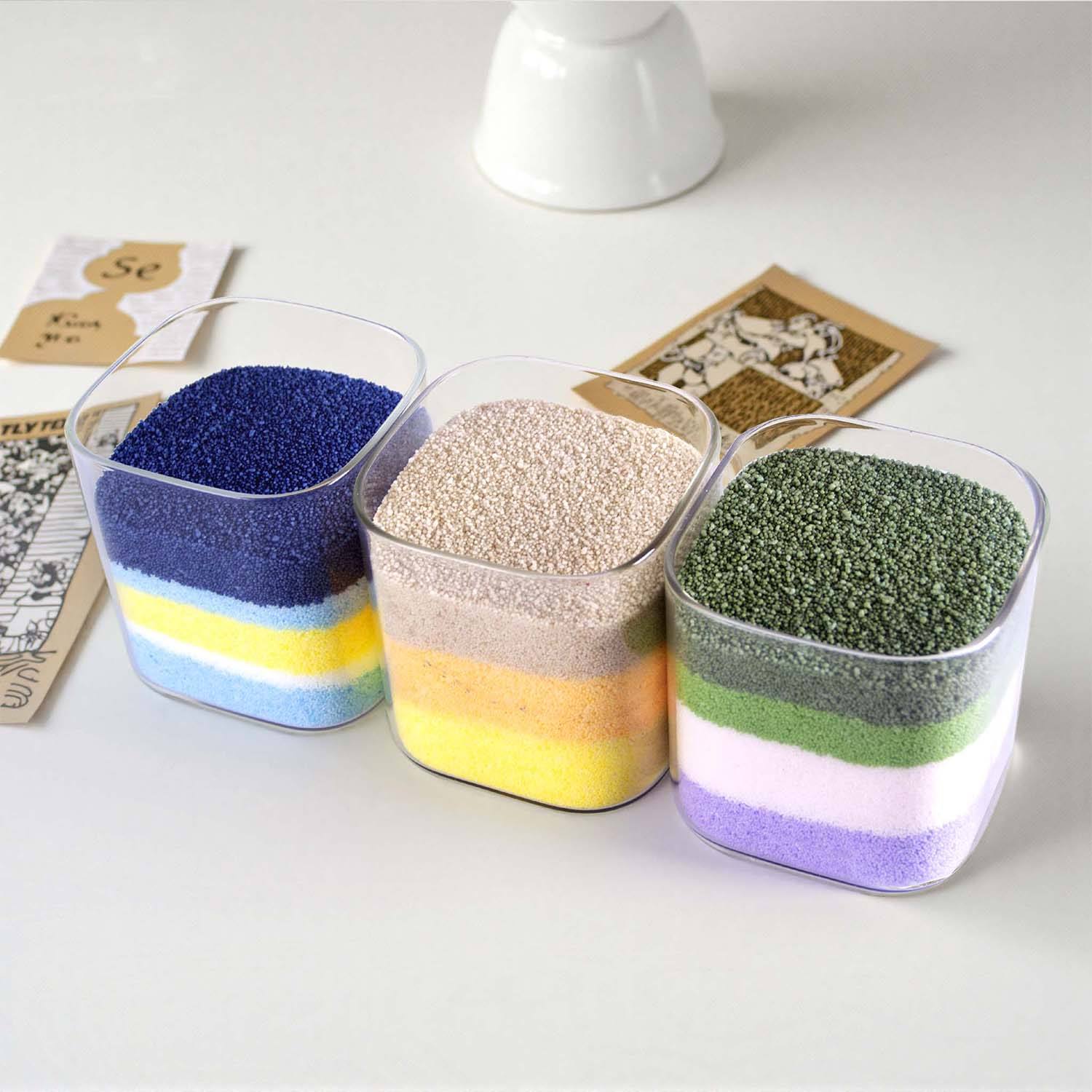 Layers of colored sand wax granules in clear glass vessels